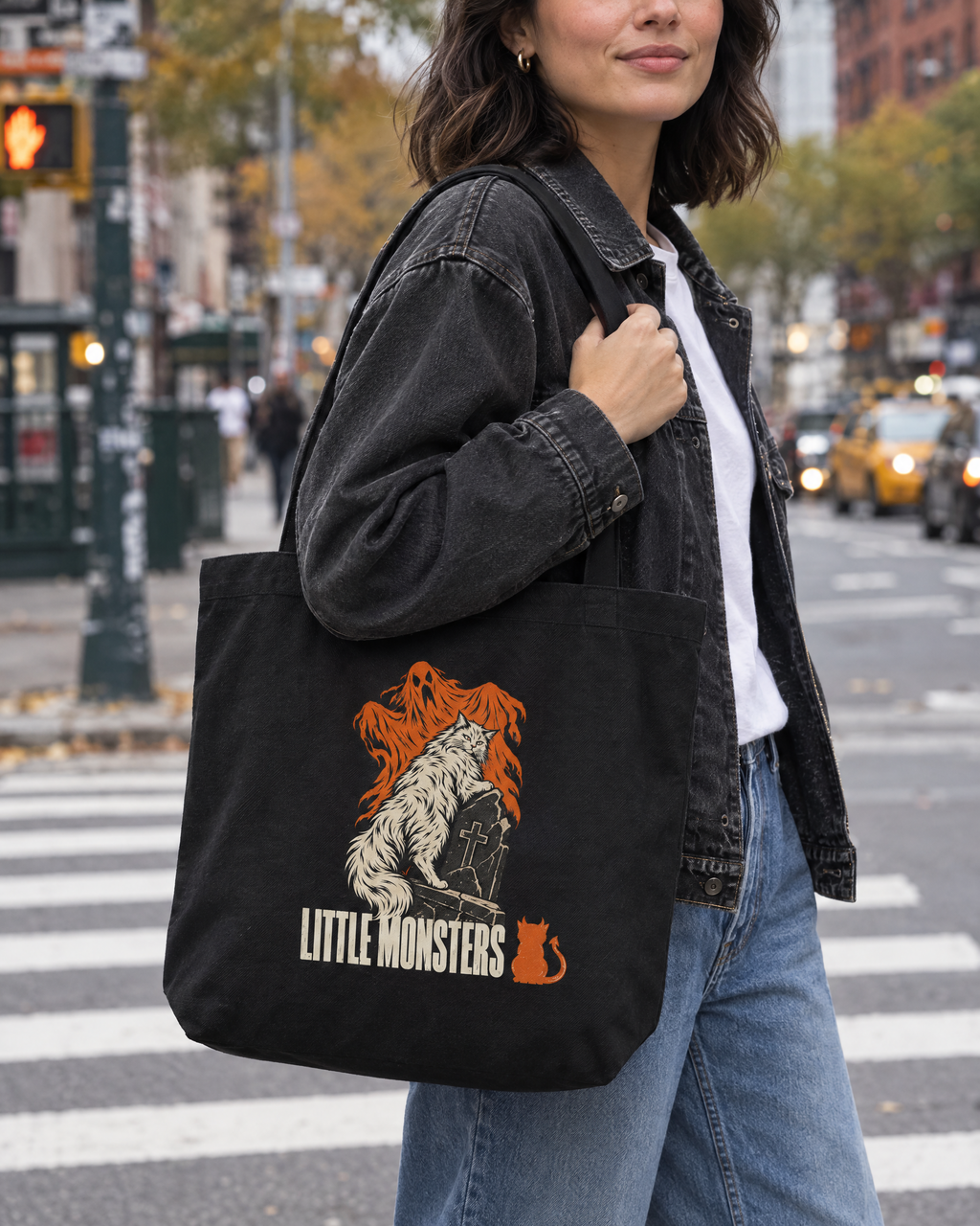 Close-up of the Little Monsters Halloween 2026 graveyard cat tote bag worn on the shoulder