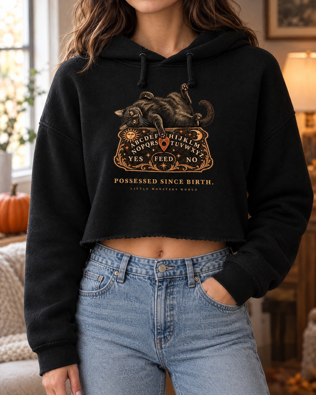Close-up of the Possessed Since Birth cropped hoodie worn with light jeans, showing the print and the cropped hem